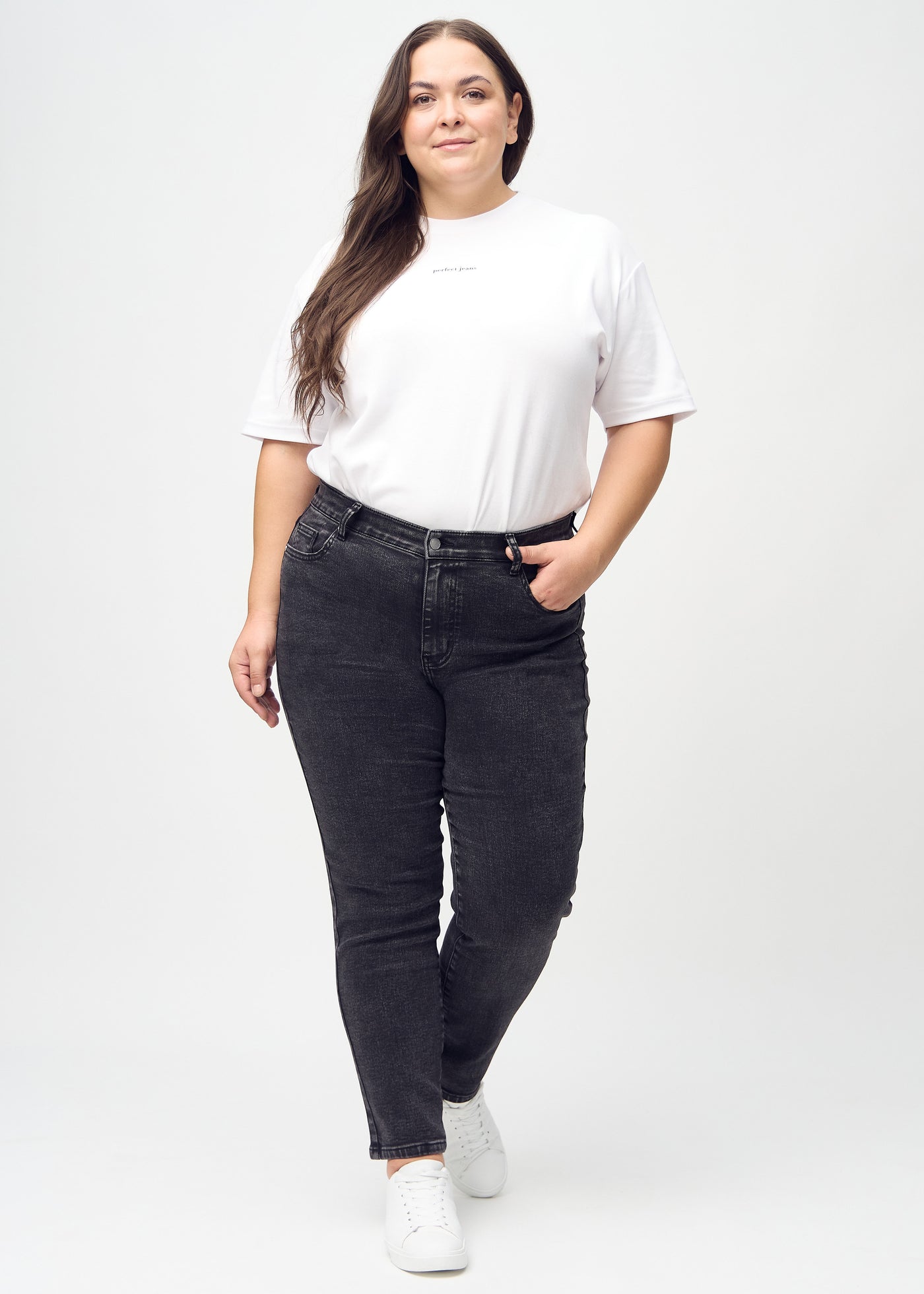 Fuldt billede af en plus-size model i mørkegrå denim slim jeans.