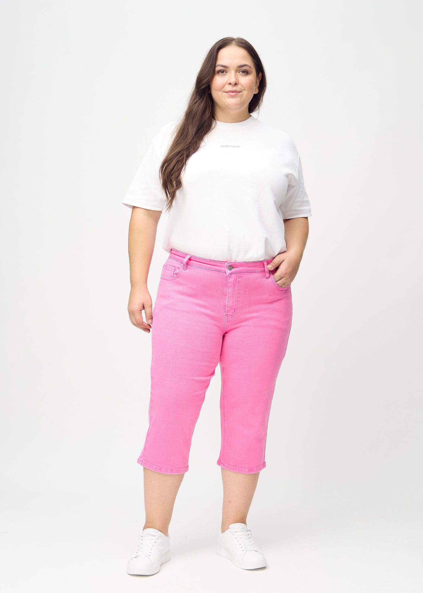 Fuldt billede af en plus-size model i lyserøde regular capris.