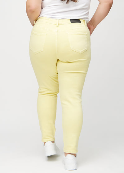 Lysegule slim jeans set bagfra på en plus-size model, så man kan se hele produktet.